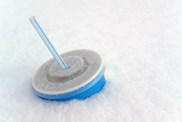 照片背景与一个纸杯柠檬水，一个塑料盖和一根吸管。街上的垃圾图片下载