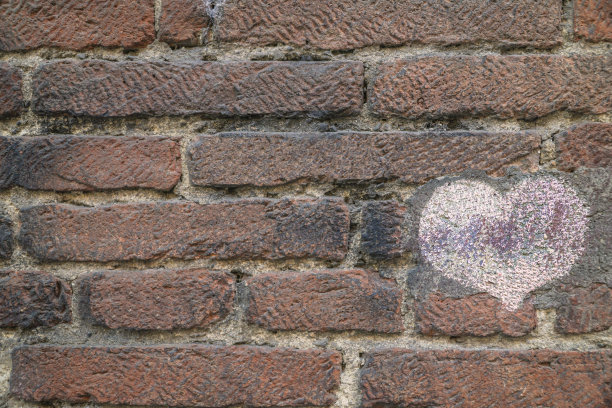 画在砖墙上的粉色心图片下载