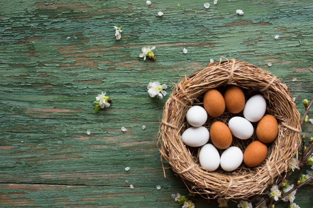 鸡蛋放在篮子里，放在旧的绿色木头上图片下载