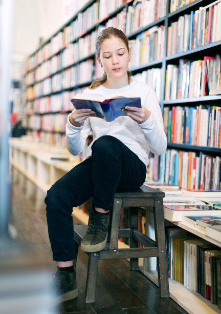 十多岁的女孩坐在图书馆的阶梯上图片下载