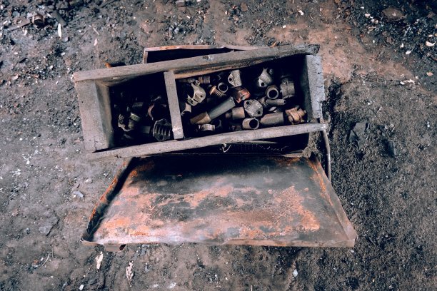 生锈的、肮脏的工具箱在积满灰尘的地板上图片下载