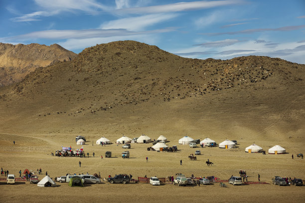 从上面的照片。秋天的风景。山谷前有蒙古包和小车，山前有大群羊和天空。沙漠。阿尔泰。蒙古西部。亚洲。图片下载