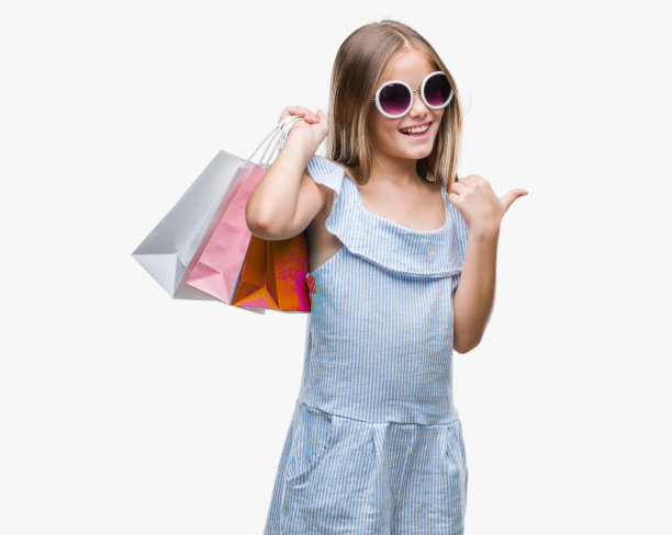 年轻美丽的女孩拿着购物袋在销售孤立的背景指向和显示与拇指向上的一边与幸福的脸微笑图片下载