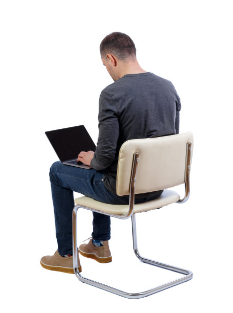 一个坐在椅子上拿着笔记本电脑的男人的后视图。图片下载