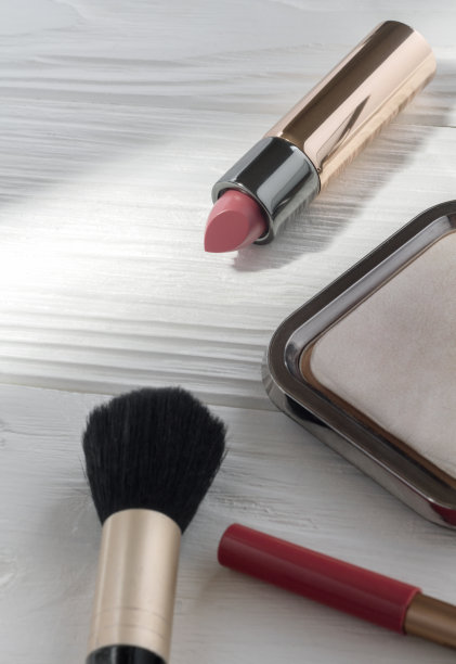 粉色口红和化妆配件在木制的白色背景图片下载