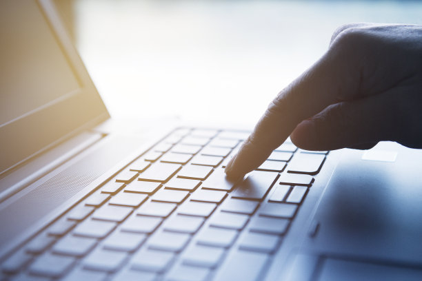 这只手按在笔记本电脑的键盘上。图片下载