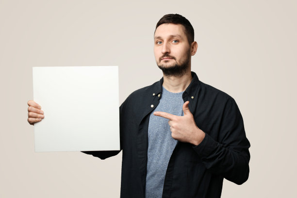 蓄着胡子戴着帽子的白人举着横幅(海报)，上面有空白的文字图片下载