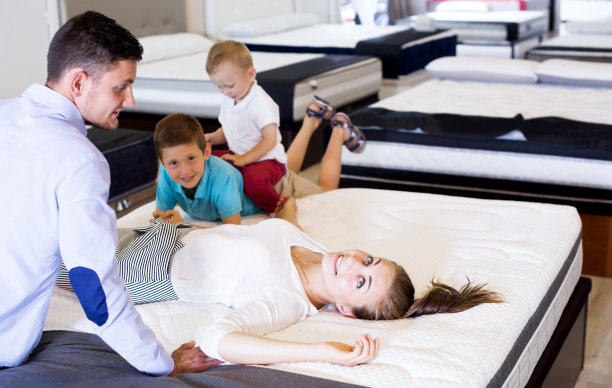 和家人一起测试床垫质量的女孩图片下载