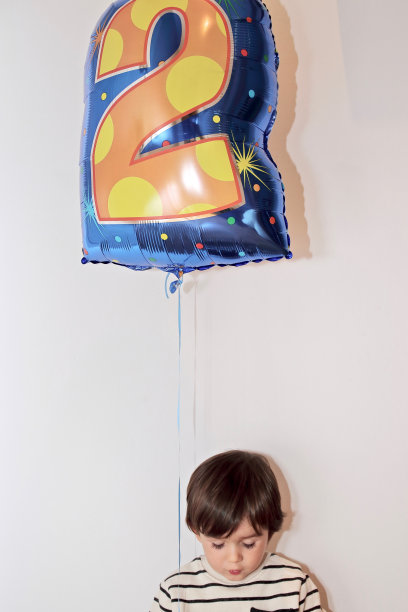 两岁的小男孩在他的生日聚会上拿着一个气球图片下载