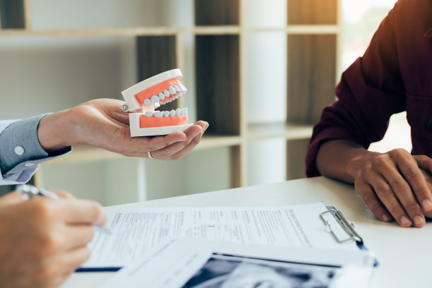 亚洲男性牙医手持笔在笔记本上写下病人的病史清单。图片下载