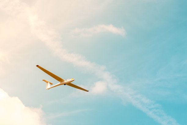 滑翔机在蓝天白云和阳光下飞行图片下载