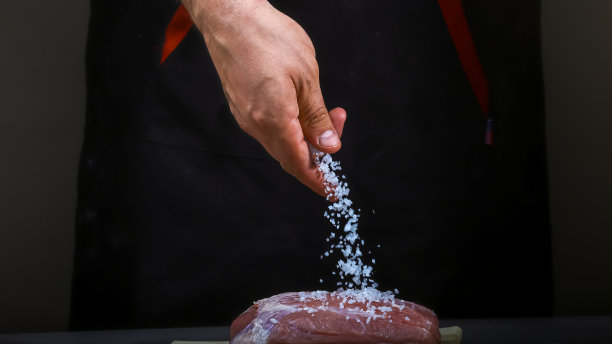 厨师亲手加入盐。烹饪牛排里脊。步骤的过程。食品的概念图片下载