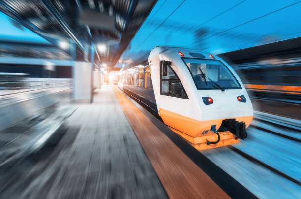 夜间在火车站上移动的火车。城市景观与现代高速列车在运行的铁路月台与照明在黄昏。城际交通工具。客运铁路旅行图片下载