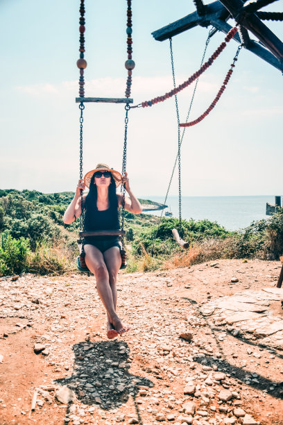 正面的女人在夏天的海滩荡秋千图片下载