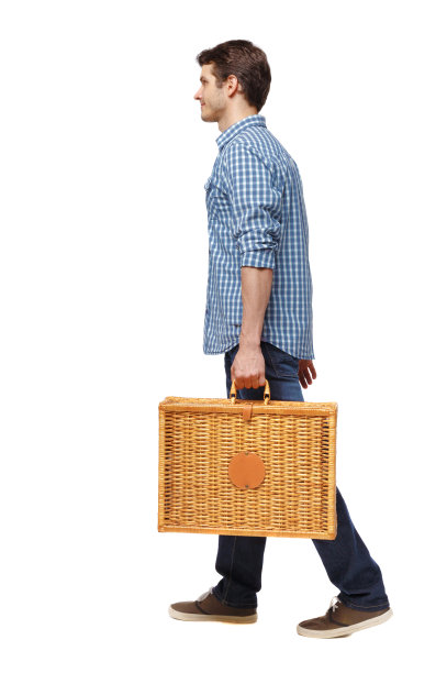 一个带着野餐袋走路的男人的侧视图。图片下载