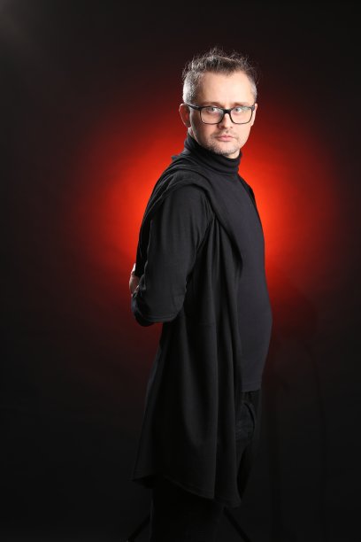 一个戴着眼镜，穿着黑色衣服，背景是黑色的年轻男子的肖像图片下载