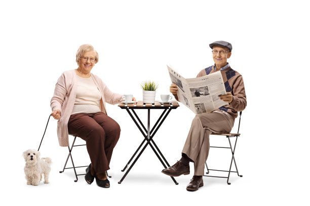 老夫妇和他们的狗坐在一张桌子旁，享受着一杯咖啡图片下载