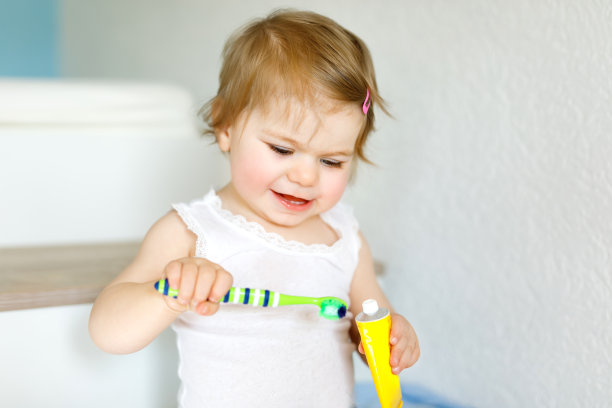 小女孩拿着牙刷，开始刷牙。蹒跚学步的孩子正在学习清洁乳牙。图片下载