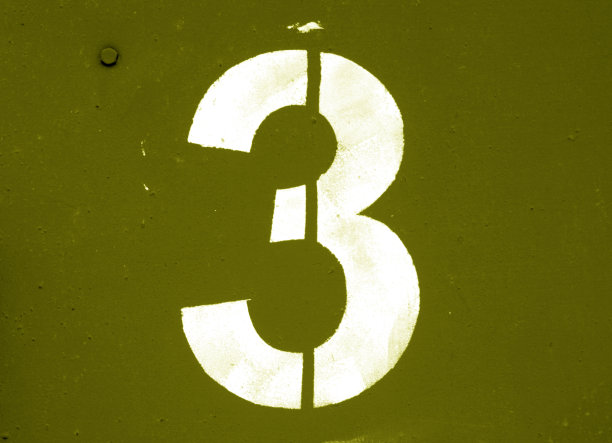 金属墙上的黄色模板上的三号。图片下载