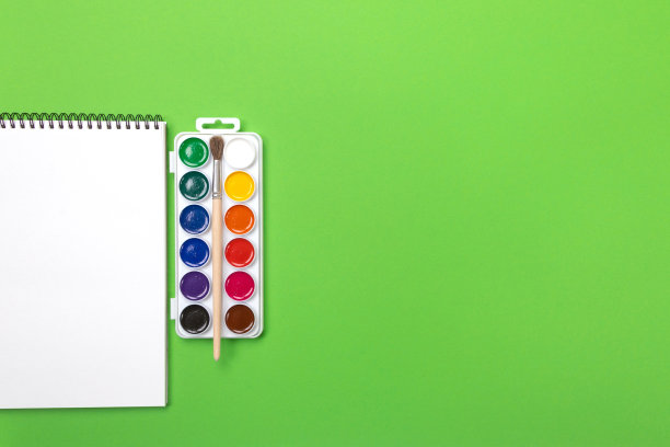 水彩颜料和刷子与画布绘画与copyspace在绿色的背景图片下载