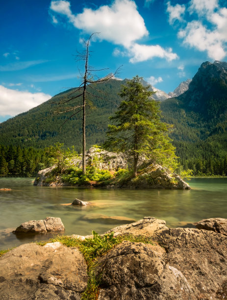 在神秘的山湖中放松，绿水里面有岩石和树木。图片下载