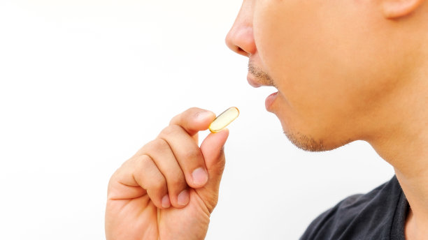一名男子在白色背景下服用补充剂。图片下载