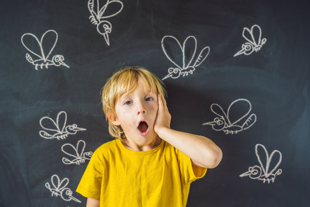 在黑色的背景上，男孩被蚊子咬了一口。在黑板上用粉笔画蚊子图片下载