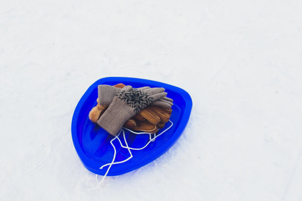 地上积着雪，红色雪橇上踏着脚印。冬季游戏和活动概念。图片下载