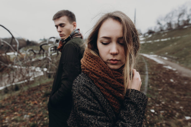 时尚时髦的女人和男人在风大的秋天公园摆姿势。感性的氛围时刻与文本空间。时尚酷夫妇创意照片图片下载