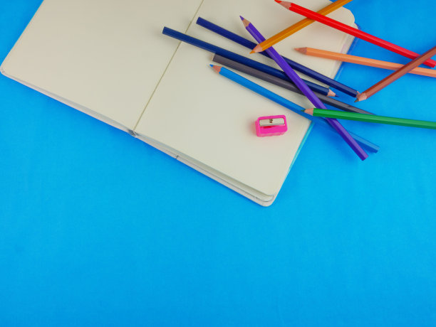 包含彩色铅笔和带复制空间的笔记本的文具俯视图扁平素材图片下载