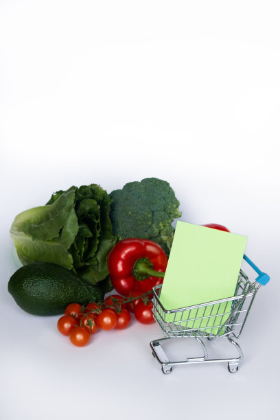 购物的概念。购物车的购物清单和不同的蔬菜在白色的背景。图片下载