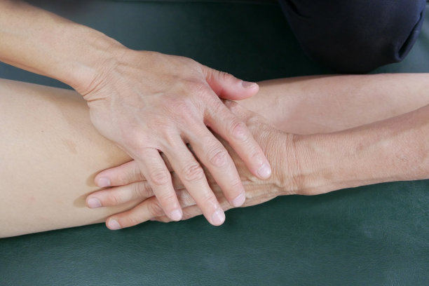 理疗师用手给病人治疗膝盖图片下载