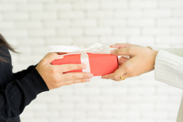 近距离女人穿着黑色毛衣和手拿红色盒子与红色蝴蝶结接收礼物的女儿在客厅圣诞快乐或新年快乐的节日和母亲节快乐的概念图片下载