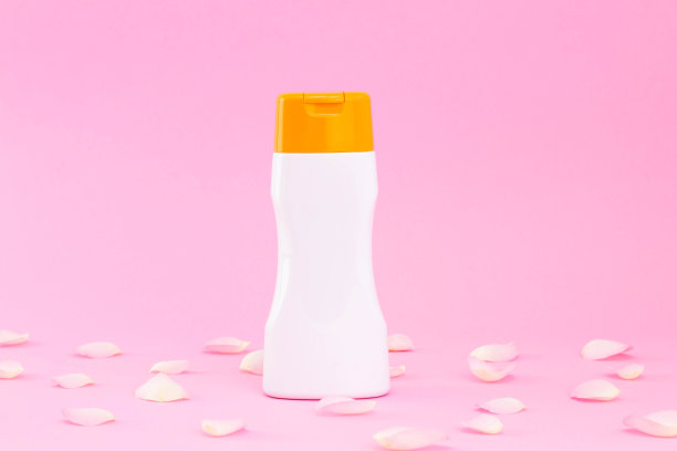 美丽化妆品瓶与玫瑰花瓣，水平品牌模拟，侧面上的粉背景。包装凝胶，乳液或霜图片下载