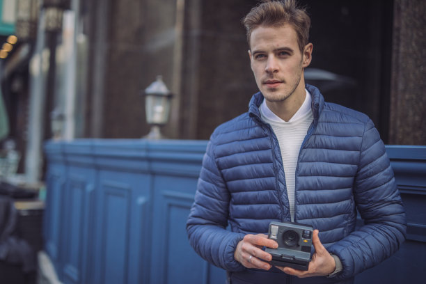穿着蓝色夹克，拿着旧相机的帅哥图片下载