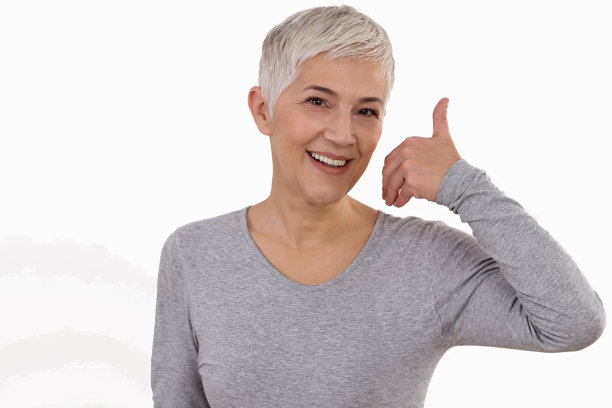 成熟的微笑女人显示拇指孤立在白色的背景。老年护肤、美容理念。图片下载