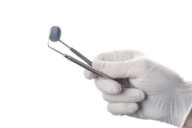 牙科镜和器械在医生的手上用橡胶手套隔离在白色背景上。图片下载