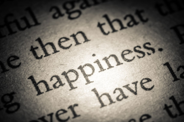 “幸福”字在一本打开的书的旧页上特写宏。复古、垃圾、老式、复古风格的照片。图片下载