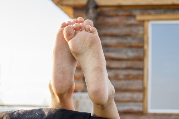 光着脚的婴儿的脚在一个乡村木屋的背景上图片下载