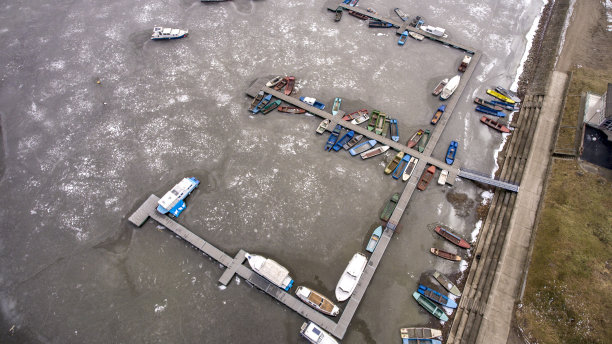 无人机拍摄的冬季冰冻湖泊与船只的鸟瞰图图片下载