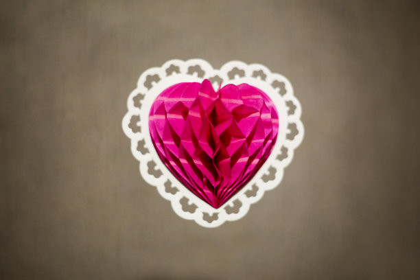 纸上的粉色心形，白色框架，棕色背景图片下载