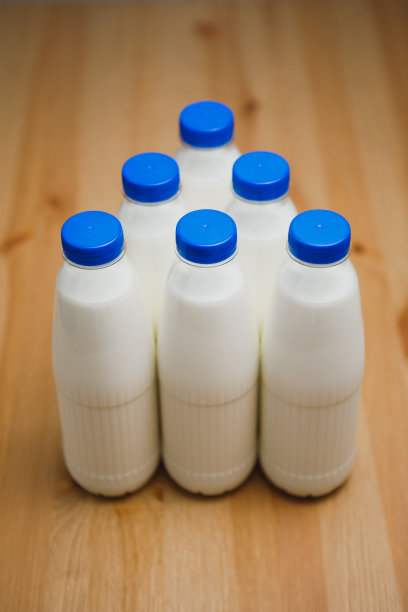 牛奶瓶放在木桌上图片下载