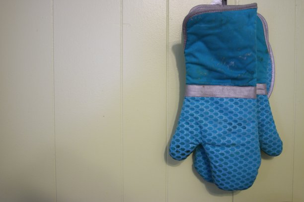 蓝色的烤箱手套挂在房间的墙上图片下载