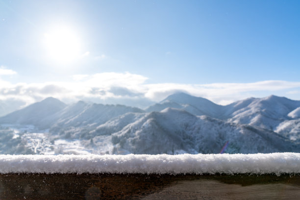 空荡荡的木板桌面前面是模糊的雪山景观背景。透视木材在模糊的冬季景观背景照片蒙太奇，产品展示或模拟您的产品。图片下载