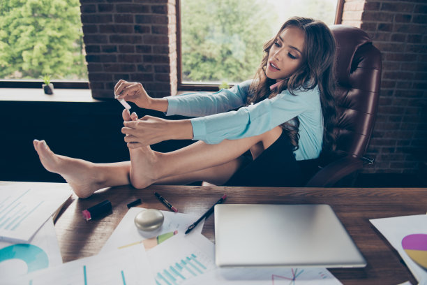 近距离的侧面资料照片，漂亮的她，她的商务夫人没有空闲分钟趾甲锉过程美交谈投资者，同时坐在舒适的办公室大椅子，穿着正式的穿西装图片下载