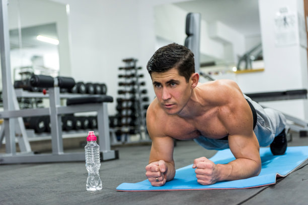 年轻人在健身房做平板支撑运动图片下载