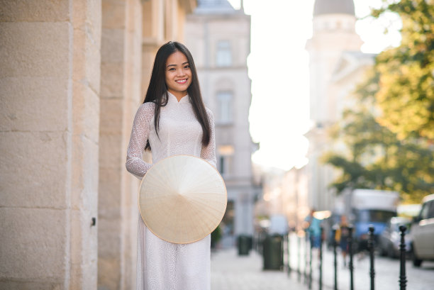 近距离的肖像漂亮的亚洲女孩穿着敖代服装与越南锥形帽子。图片下载
