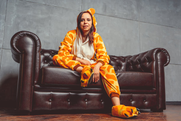 快乐的少女穿着有趣的睡衣，卡通风格的睡衣，积极的面部表情，在灰色的背景。图片下载