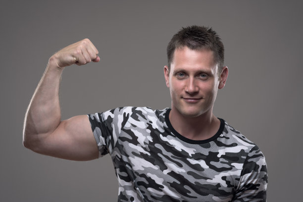 肖像的运动员肌肉健康的男性模型在军队衬衫弯曲的手臂图片下载