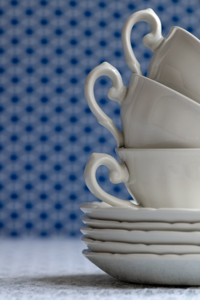 白色花边桌布上的白色杯子和盘子。图片下载